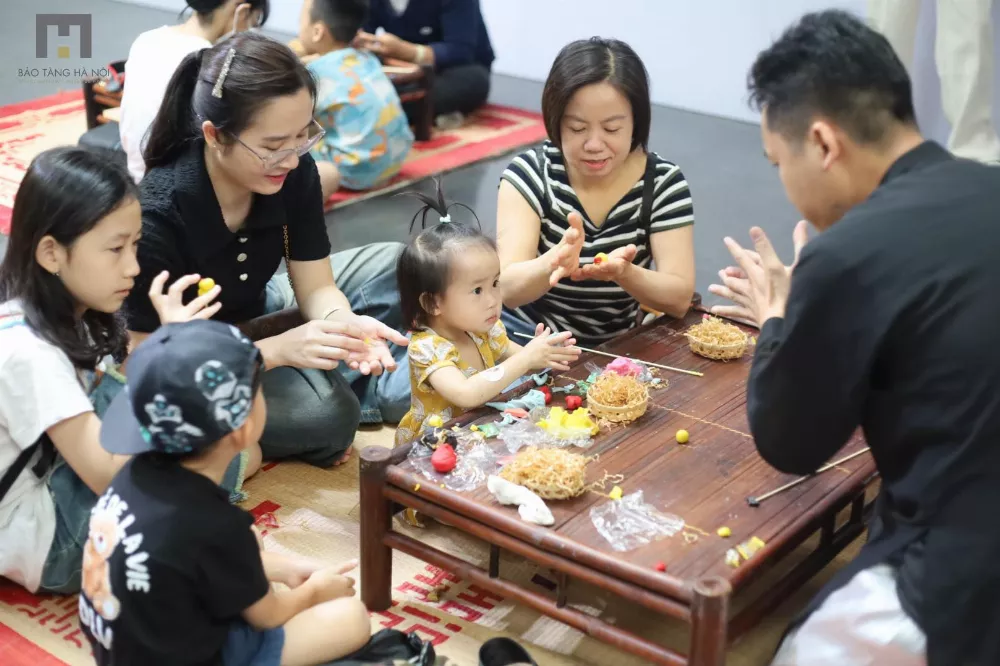 Hình ảnh nghệ nhân hướng dẫn các bạn sinh viên cùng các em nhỏ cách nặn tò he