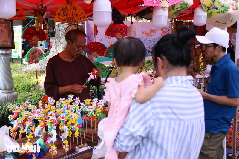 Khách tham quan thích thú xem nghệ nhân nặn tò he biểu diễn