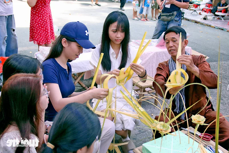 Khách tham quan trải nghiệm cùng nghệ nhân xếp lá dừa nghệ thuật